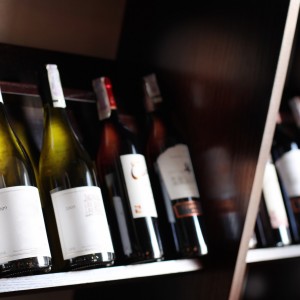 Wine bottles on a wooden shelf.