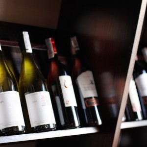Wine bottles on a wooden shelf. Wine bottles on a wooden shelf.